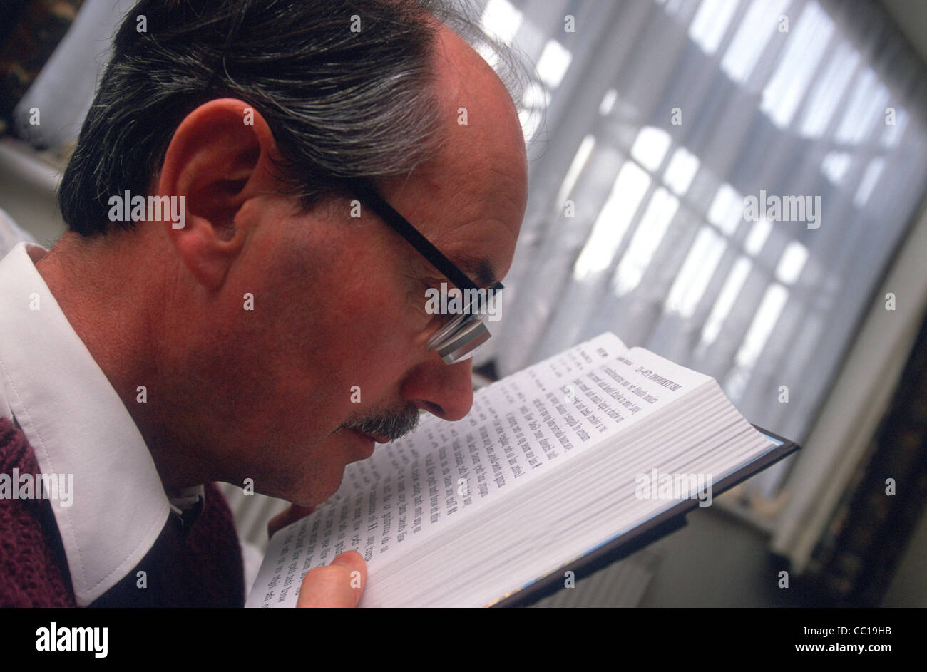 Ipovedenti uomo utilizzando specialmente adattato per occhiali da lettura, Hanwell, London, Regno Unito. Foto Stock