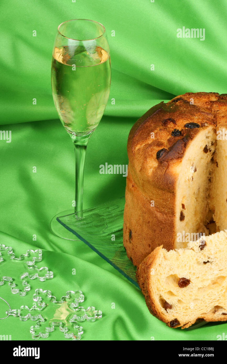 Il Panettone il Natale in Italia la torta di frutta è servita su una lastra di vetro trasparente con un bicchiere di spumante e alcuni ornamenti Foto Stock