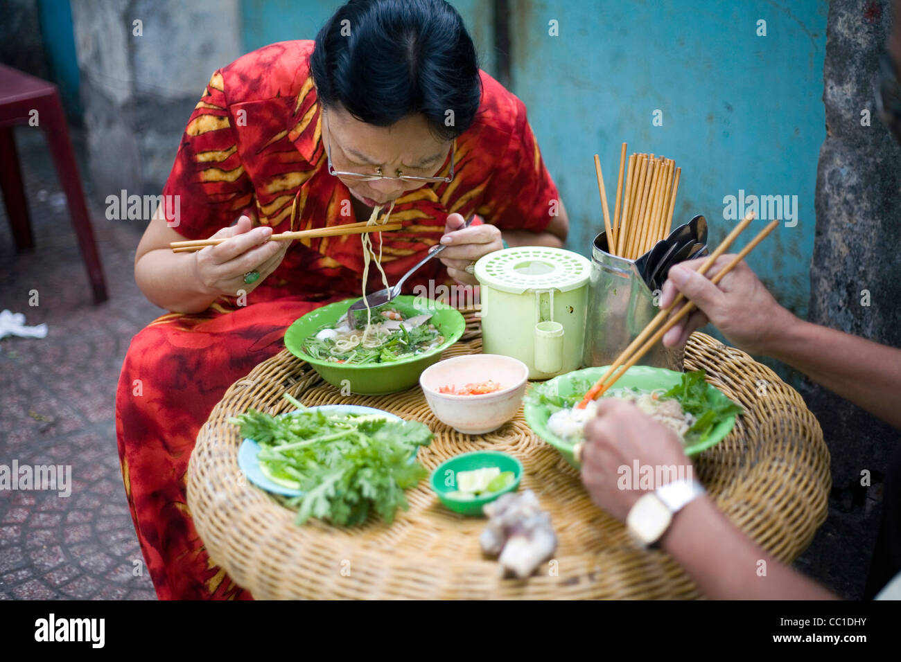 Un paio mangiare Pho noodle soup per colazione in corrispondenza di un lato della strada cafe, Ho Chi Minh City (ex Saigon), Vietnam Foto Stock