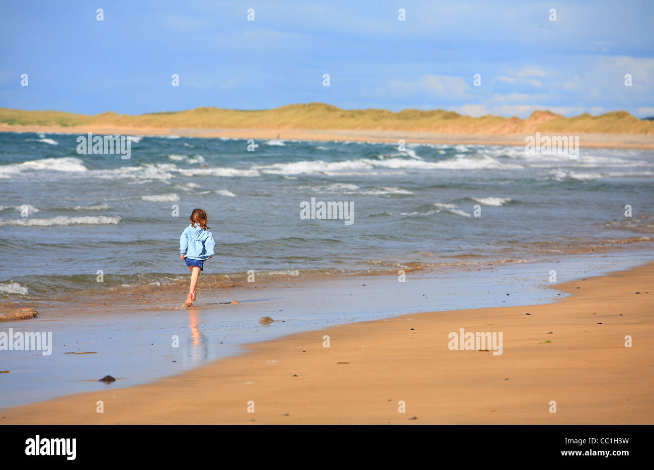 Giovane ragazza camminare sulla spiaggia Streedagh. Sligo. L'Irlanda Foto Stock