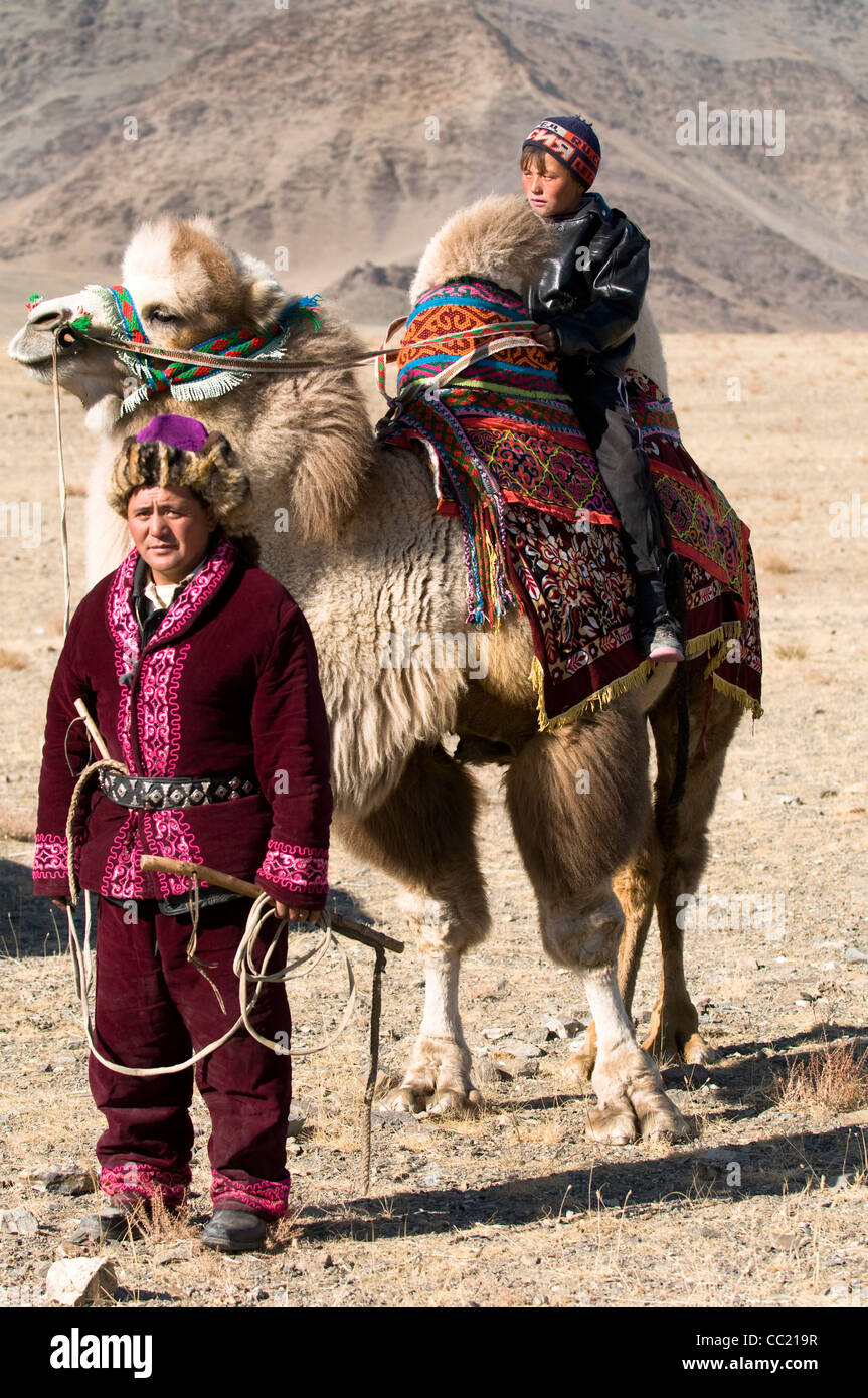 Un herder kazako con suo figlio nella vasta steppa di Altai regione della Mongolia occidentale. Foto Stock