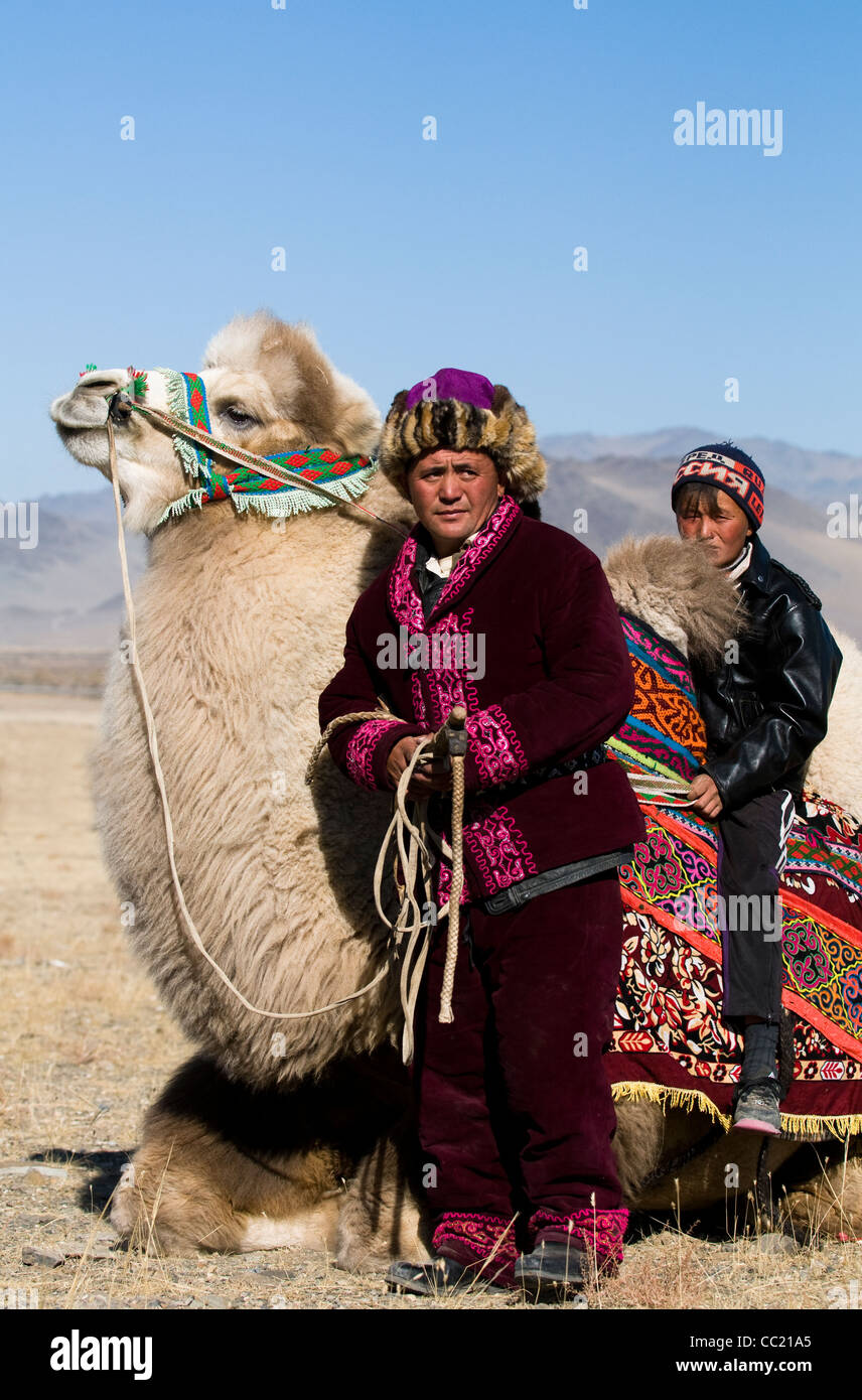 Un herder kazako con suo figlio nella vasta steppa di Altai regione della Mongolia occidentale. Foto Stock