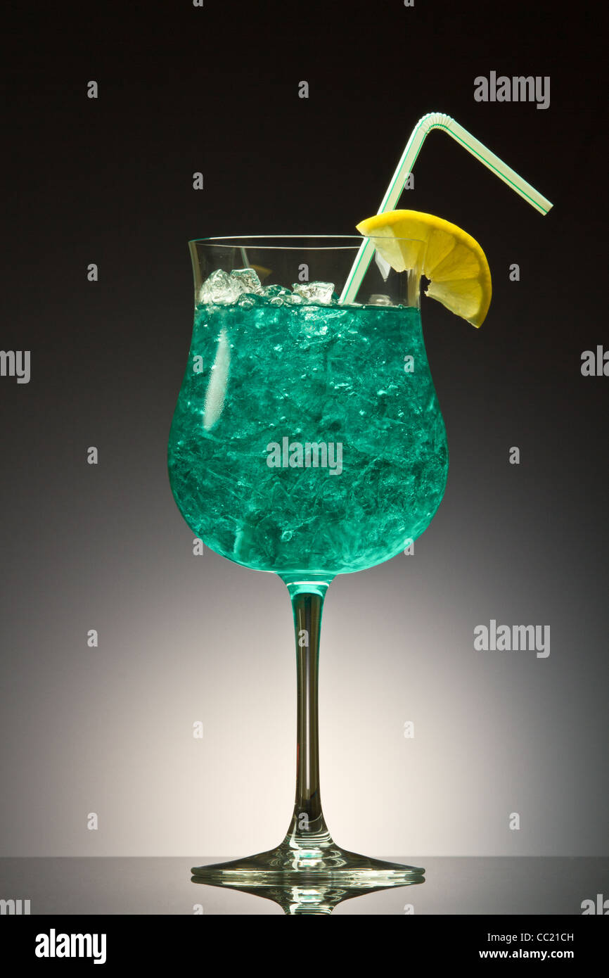La Blue Hawaiian cocktail su un gradiente di colore grigio Foto Stock