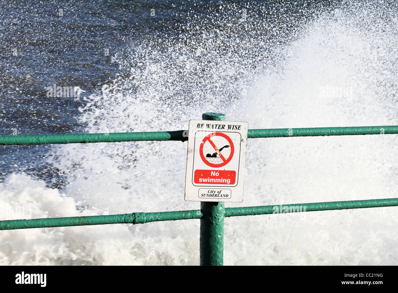 Segnaletica di pericolo essere acqua saggio n. nuoto con le onde che si infrangono in background. Foto Stock