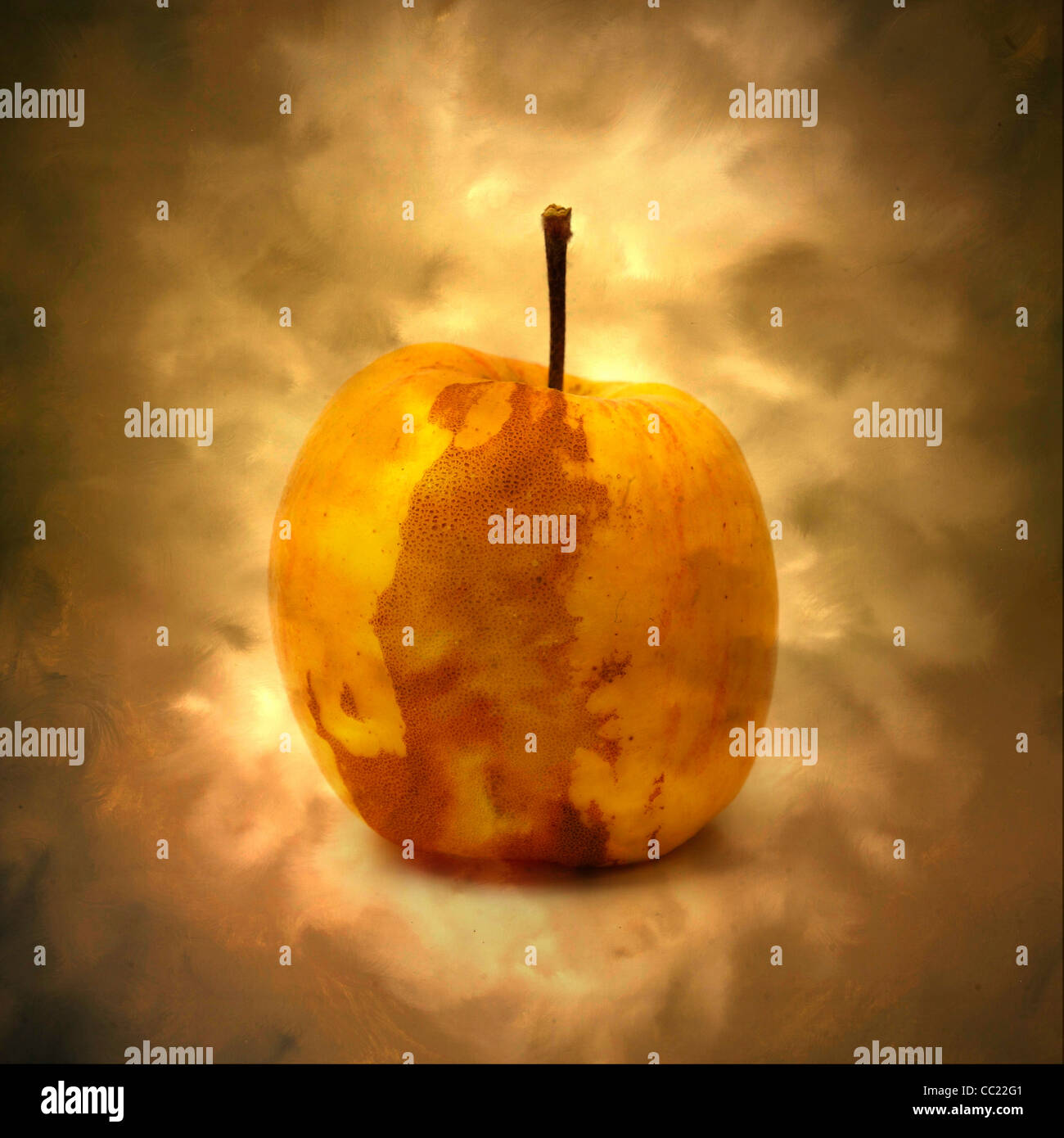 La mela dorata che si illumina su uno sfondo morbido e nebbioso crea un'atmosfera calda e invitante, enfatizzando la sua bellezza e il suo fascino unici Foto Stock