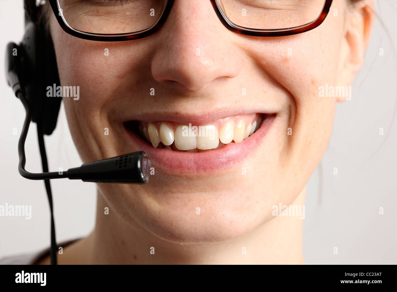 Giovane donna sta parlando, sul telefono, Internet Voice over IP, utilizzando un auricolare. Primo piano del volto. Foto Stock