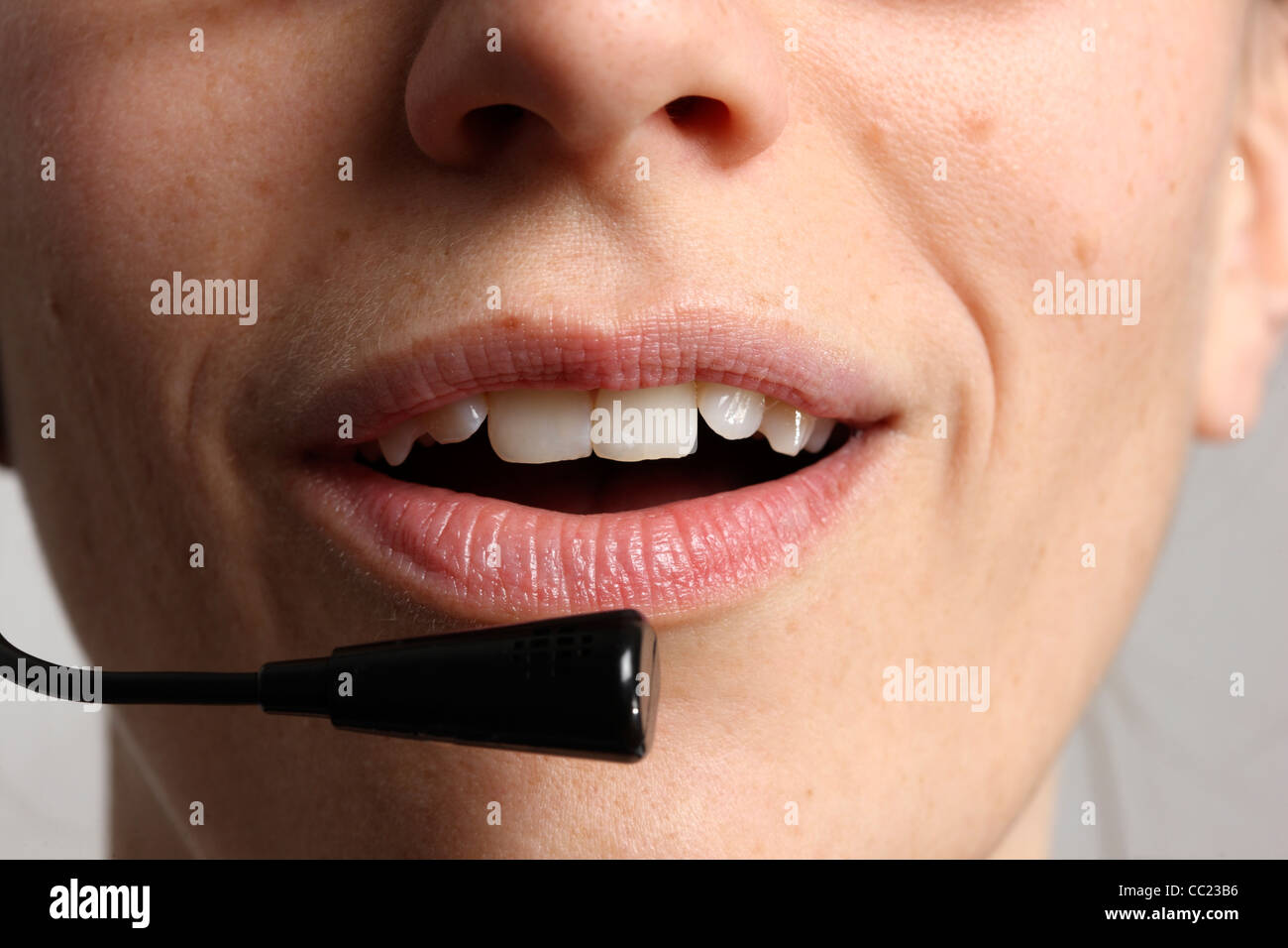Giovane donna sta parlando, sul telefono, Internet Voice over IP, utilizzando un auricolare. Primo piano del volto. Foto Stock