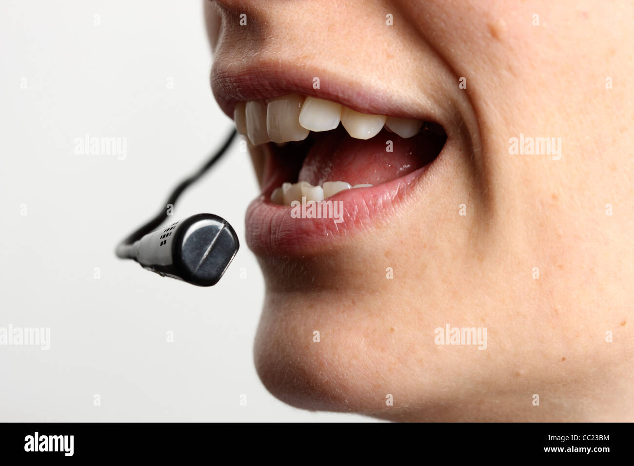 Giovane donna sta parlando, sul telefono, Internet Voice over IP, utilizzando un auricolare. Primo piano del volto. Foto Stock