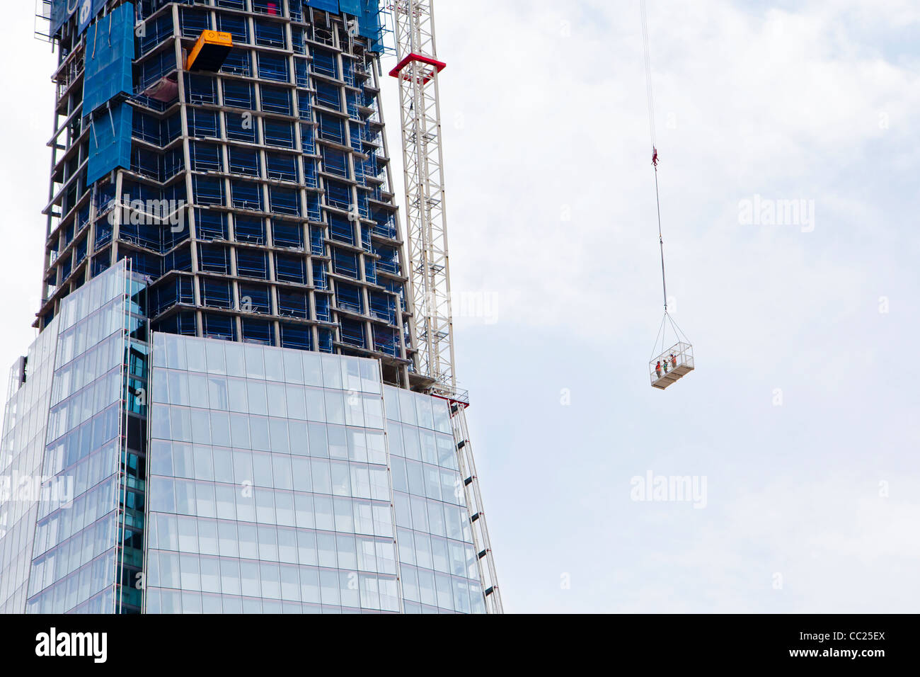 Una vista di 3 lavoratori edili e un High-Rise costruzione edilizia a Londra, Inghilterra. Foto Stock