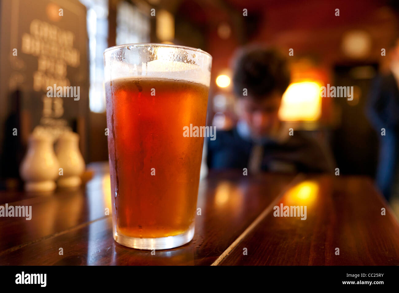 Giovane uomo gustando una birra in un pub di Londra Foto Stock