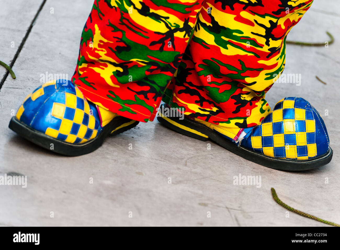 Un clown indossa scarpe sovradimensionati e colorato Pantalone mimetico durante il congresso dei clown in San Salvador El salvador. Foto Stock