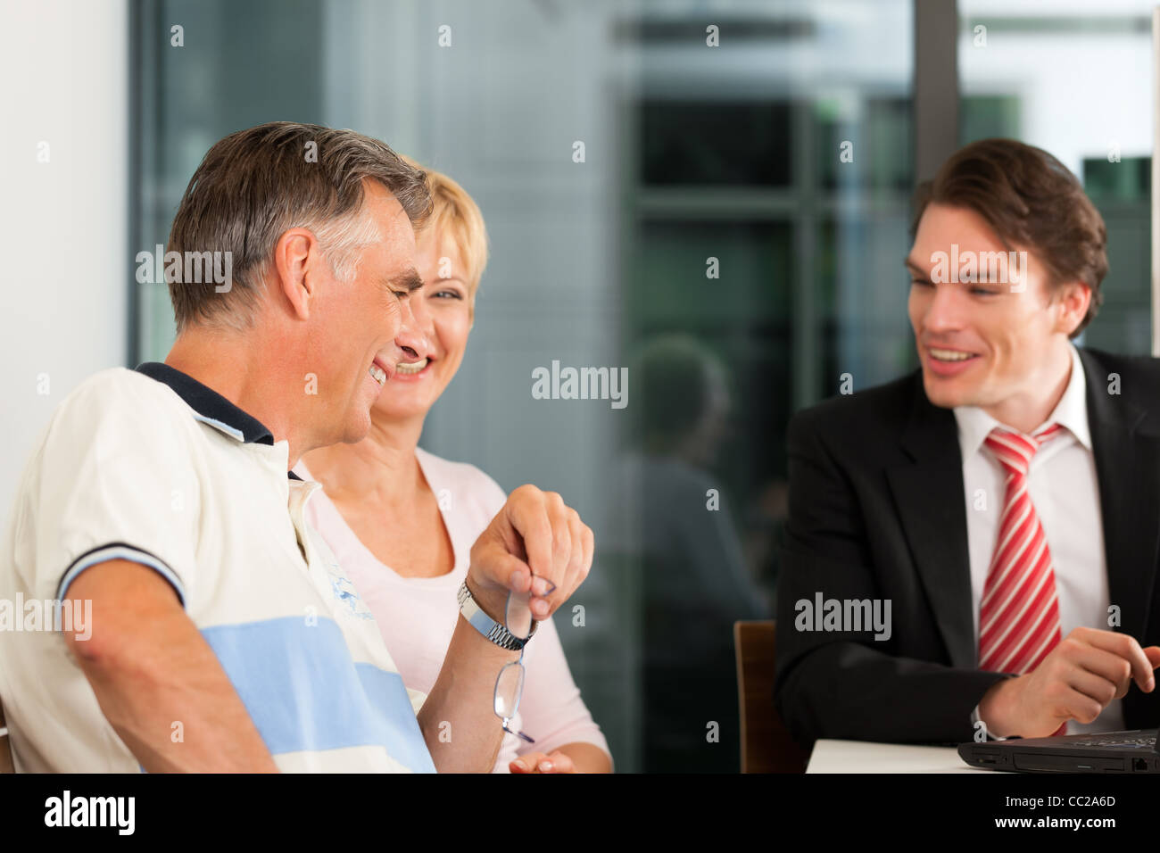 Coppia giovane con consulente finanziario - che stanno pianificando il loro pensionamento Foto Stock