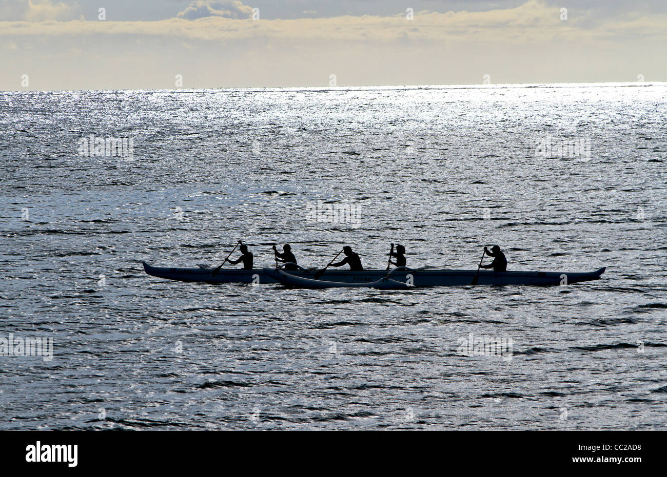 La gioventù locale di una paletta tradizionale hawaiano outrigger canoa nelle acque al largo di Molokai, Hawaii, Stati Uniti d'America. Foto Stock