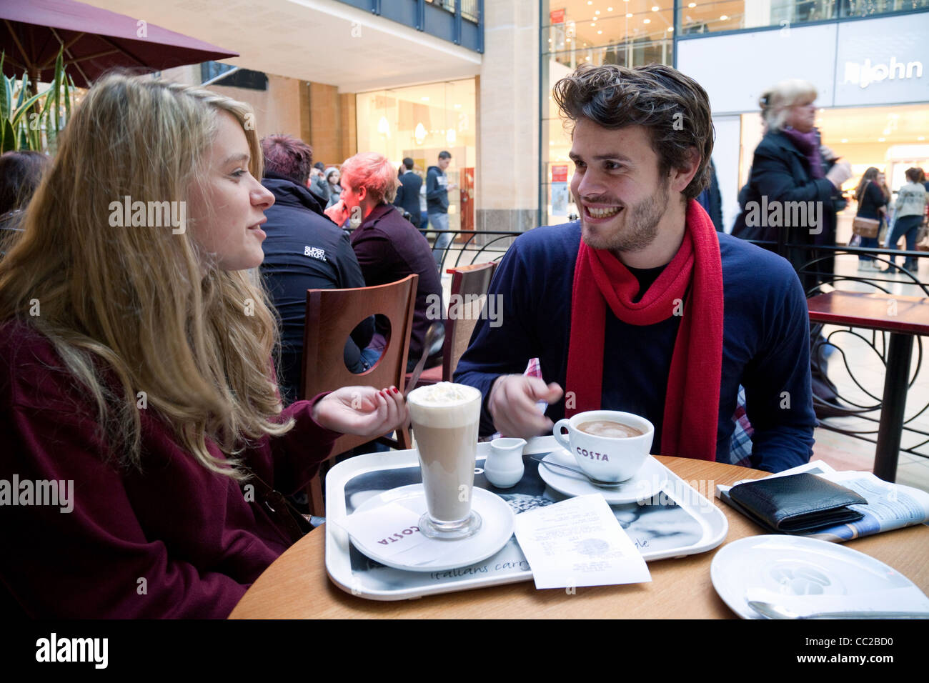 Giovane uomo e donna con caffè in Costa Coffee bar, Cambridge Regno Unito Foto Stock