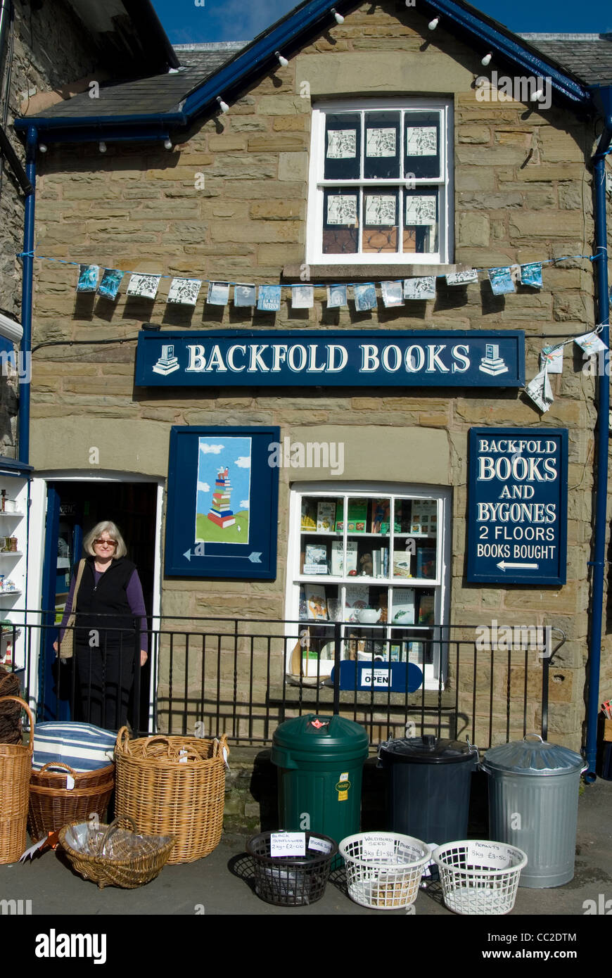Donna in piedi nel vano della porta di una libreria in Hay-on-Wye, il confine gallese città che è diventata un' booklovers destinazione. Foto Stock