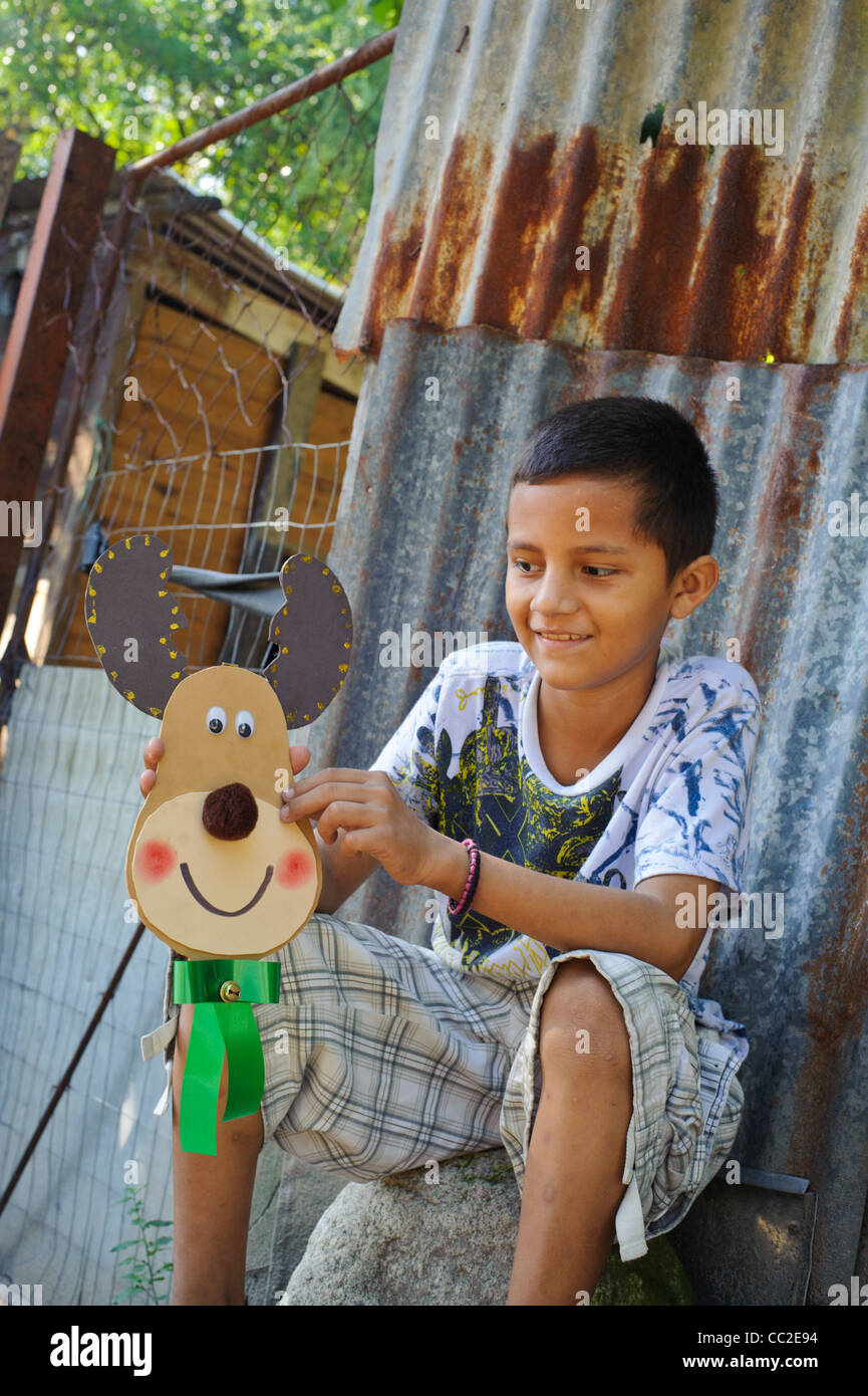 Un felice bambino con bambola in Los Bordos una delle baraccopoli in Sen Pedro Sula Honduras Foto Stock