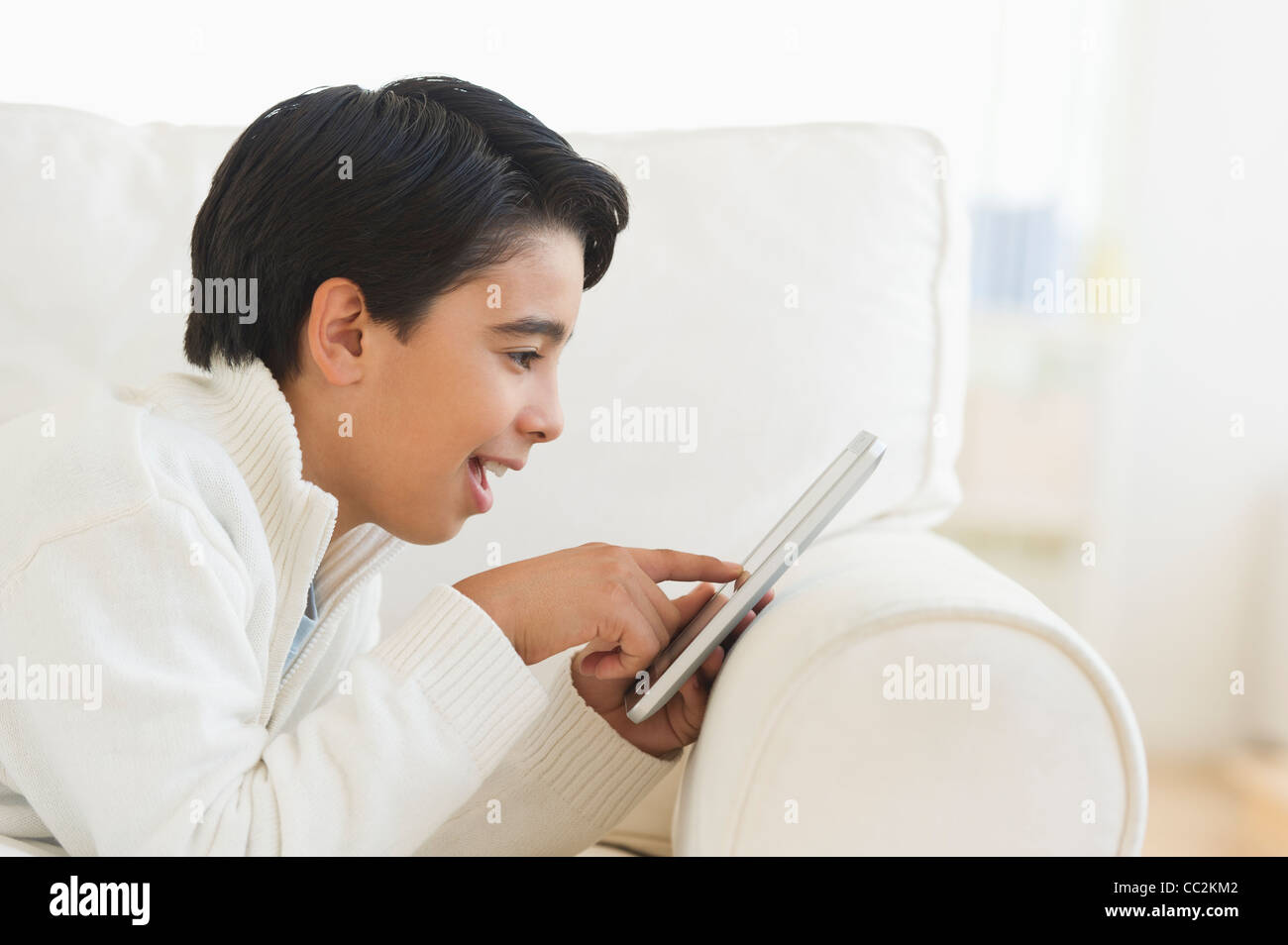 Stati Uniti d'America, New Jersey, Jersey City, ragazzo (12-13) utilizzando la tavoletta digitale sul divano Foto Stock