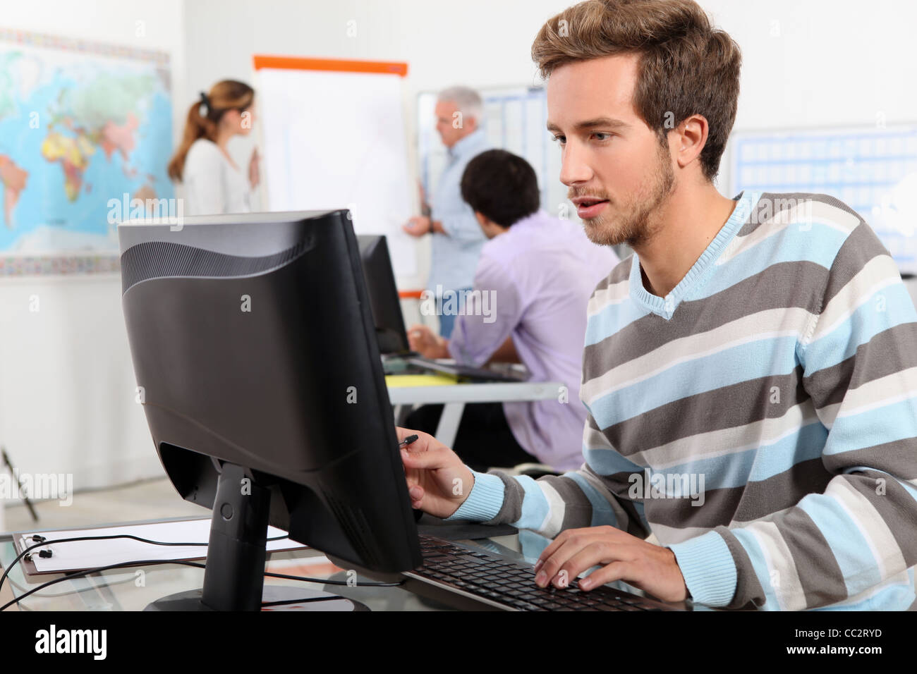 Giovane uomo che lavora a un computer Foto Stock