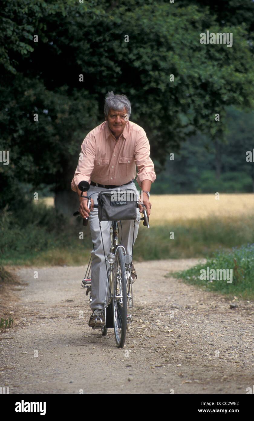 Uomo maturo ciclismo discesa percorso di paese,, South Downs National Park, Inghilterra Foto Stock