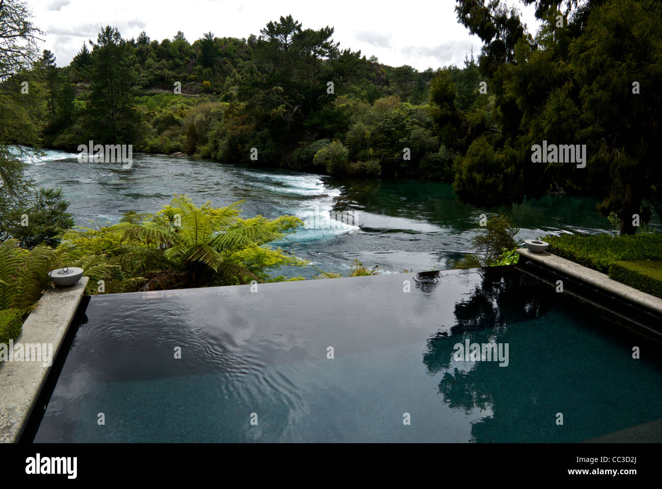 Piscina infinity affacciata cascades Fiume Waikato Huka Lodge di lusso resort di pesca Nuova Zelanda Foto Stock