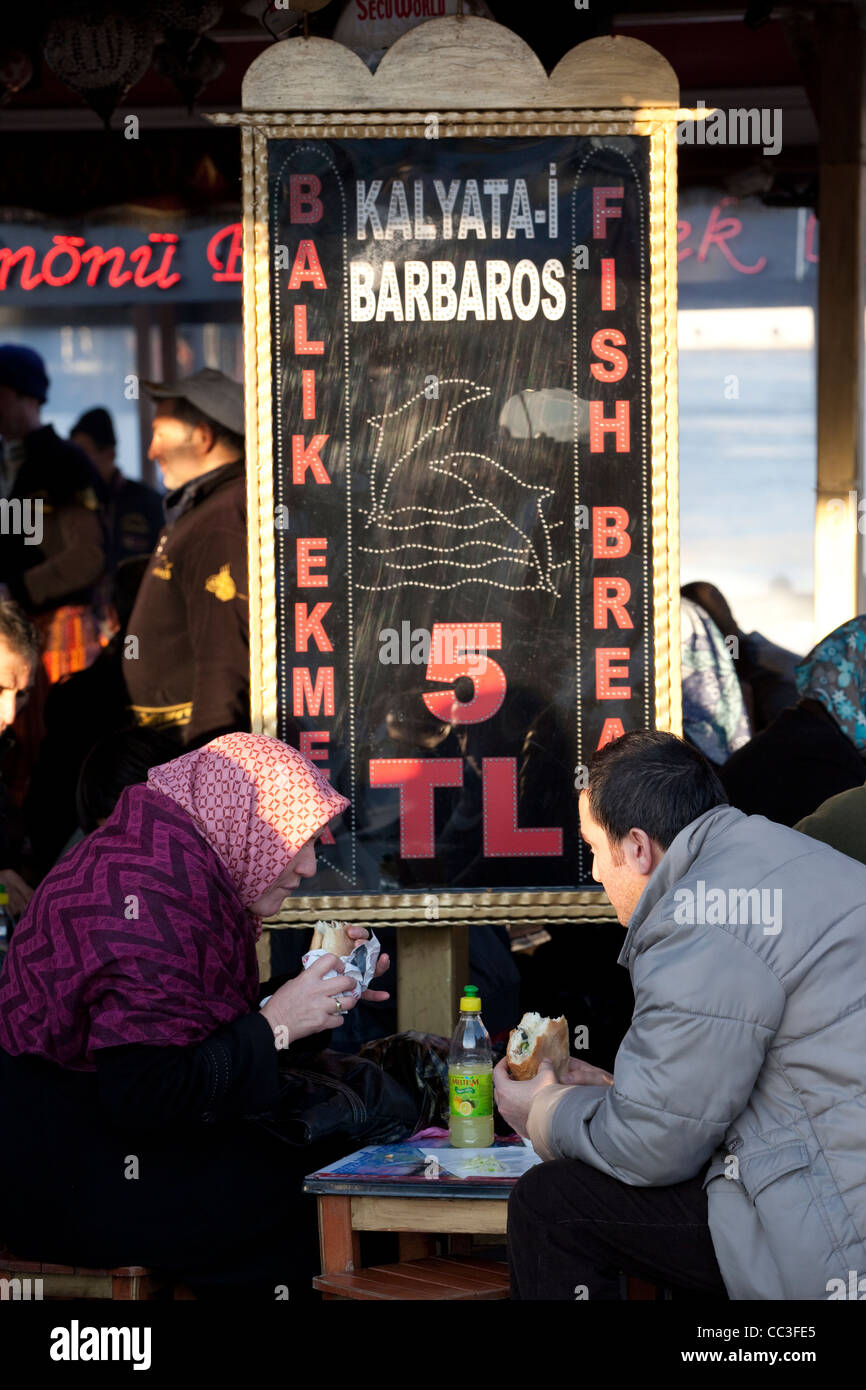 Paio mangiare pesce panini a Eminonu vicino al Ponte di Galata, Istanbul, Turchia Foto Stock