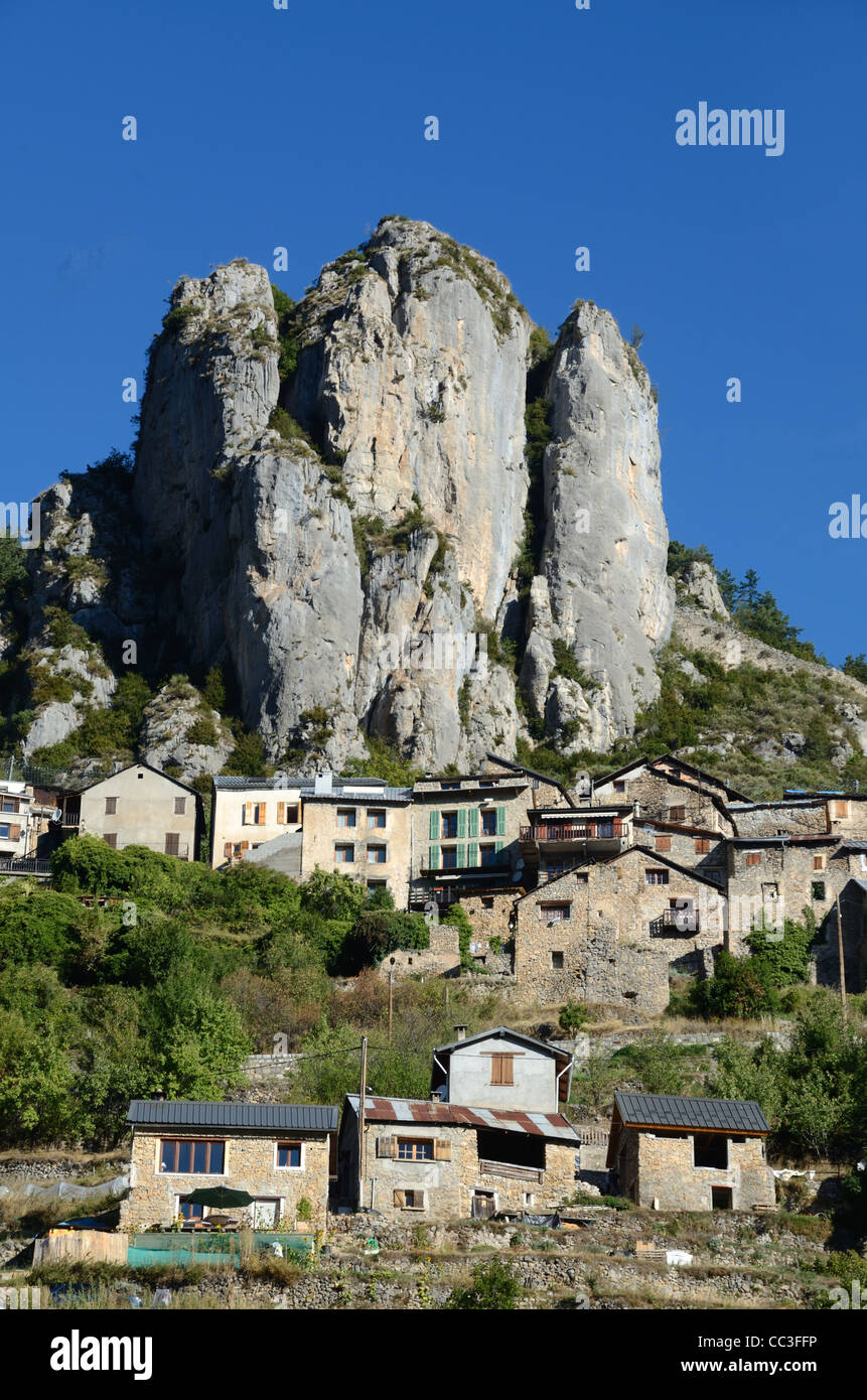 Paesaggio roccioso con il villaggio alpino arroccato di Roubion dominato Da scogliere e affioramento roccioso nel Parco Nazionale del Mercantour Alpes-Maritimes Francia Foto Stock