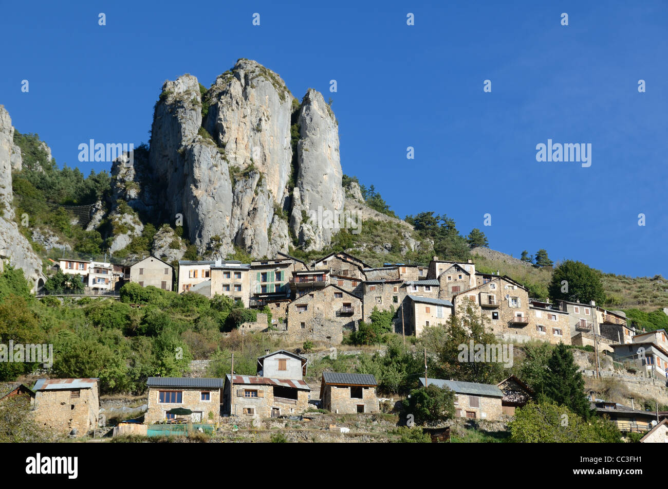 Paesaggio roccioso con il villaggio alpino arroccato di Roubion dominato Da scogliere e affioramento roccioso nel Parco Nazionale del Mercantour Alpes-Maritimes Francia Foto Stock