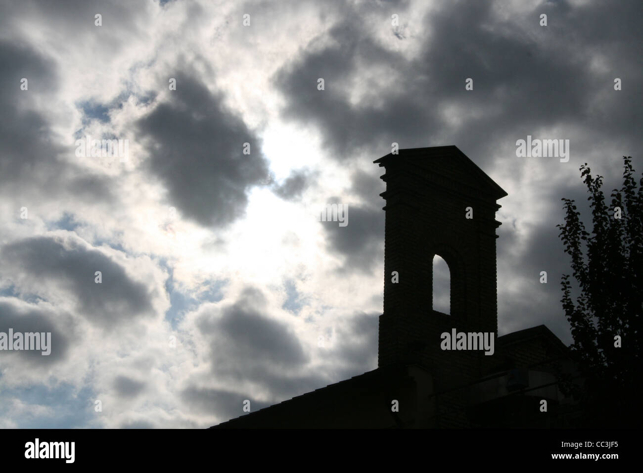 Tipo di chiesa torre campanaria e scuro moody sky Foto Stock