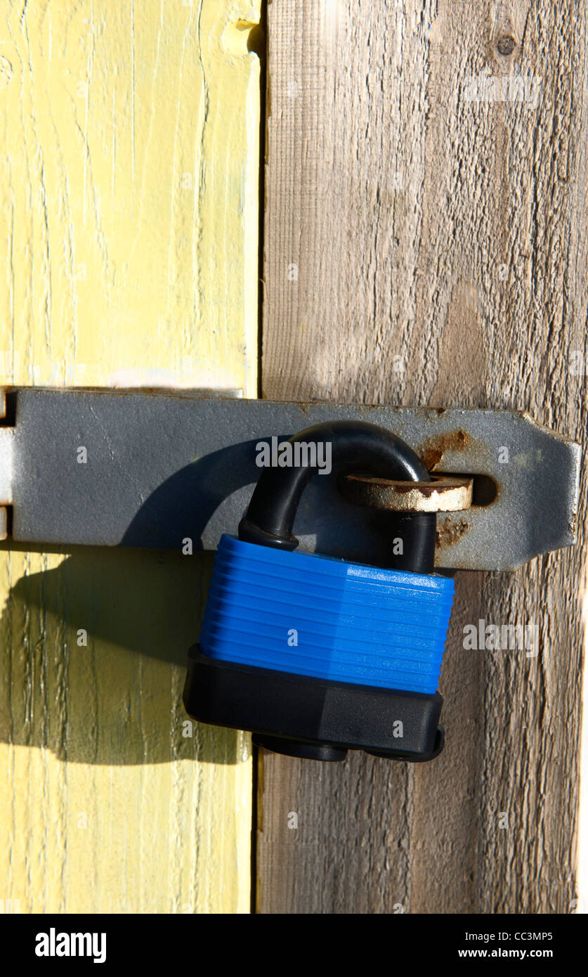 Colori luminosi con lucchetto arrugginito sulla cerniera beach hut in West Wittering, West Sussex Foto Stock