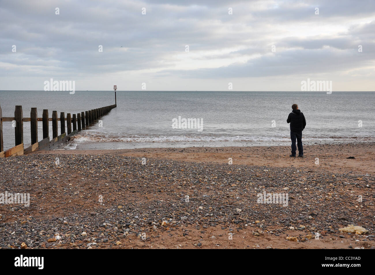 Solo l'uomo sulla spiaggia invernale. Foto Stock