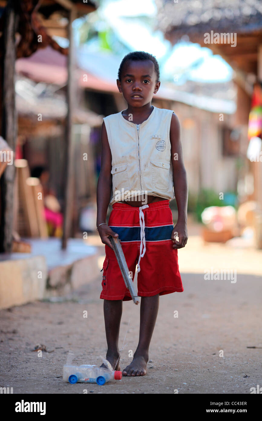 Un giovane ragazzo in Nosy Komba con il suo giocattolo riciclato auto carrello realizzato in una bottiglia di plastica e diversi cappucci tirato con una stringa. Foto Stock