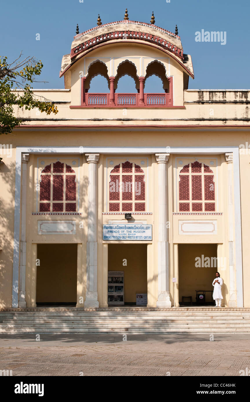 Uomo che prega nella parte anteriore della galleria e workshop, City Palace, a Jaipur, India Foto Stock