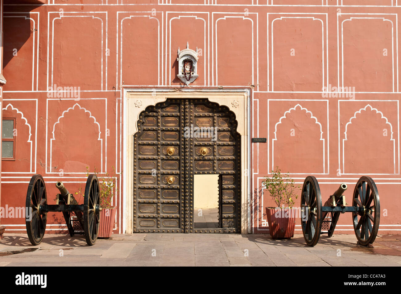 Cannoni sui lati del cancello in legno, City Palace, a Jaipur, India Foto Stock