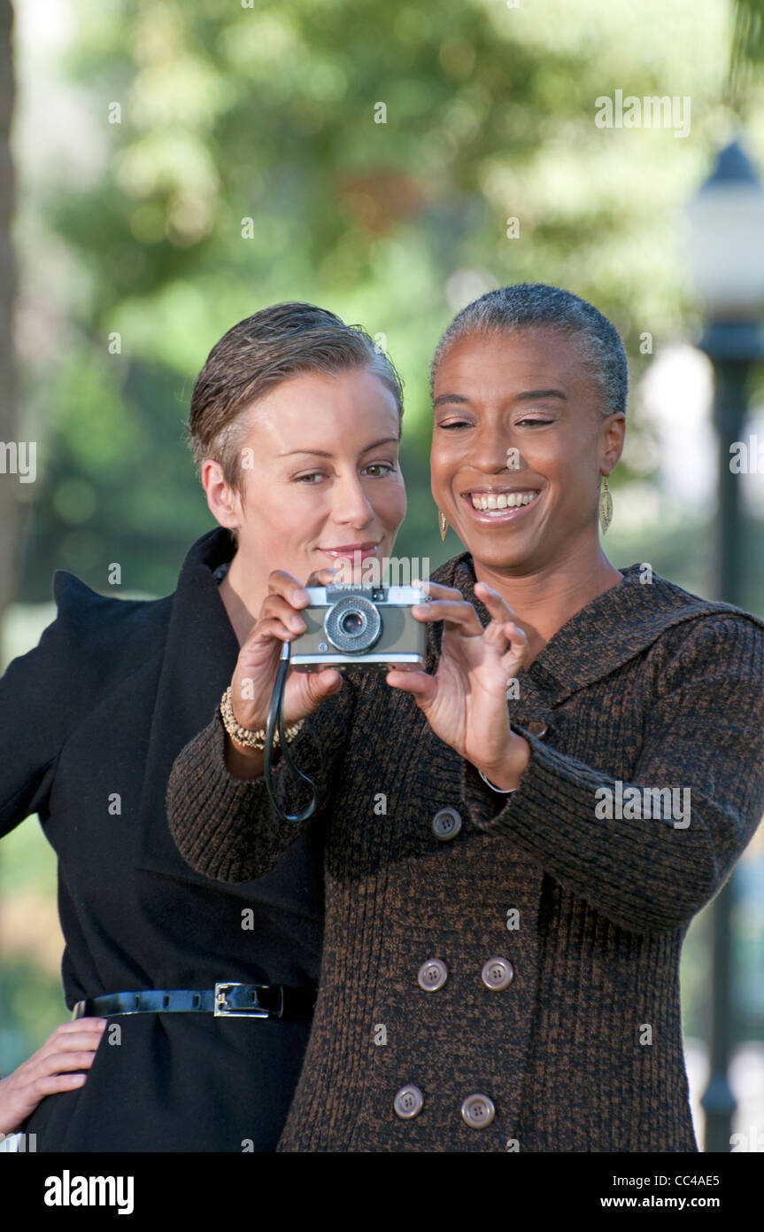 Due donna di mezza età divertirsi nel parco di scattare le foto Foto Stock