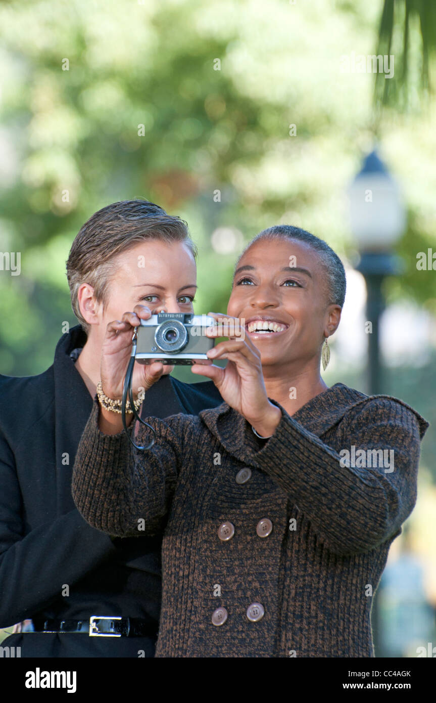 Due donna di mezza età divertirsi nel parco di scattare le foto Foto Stock