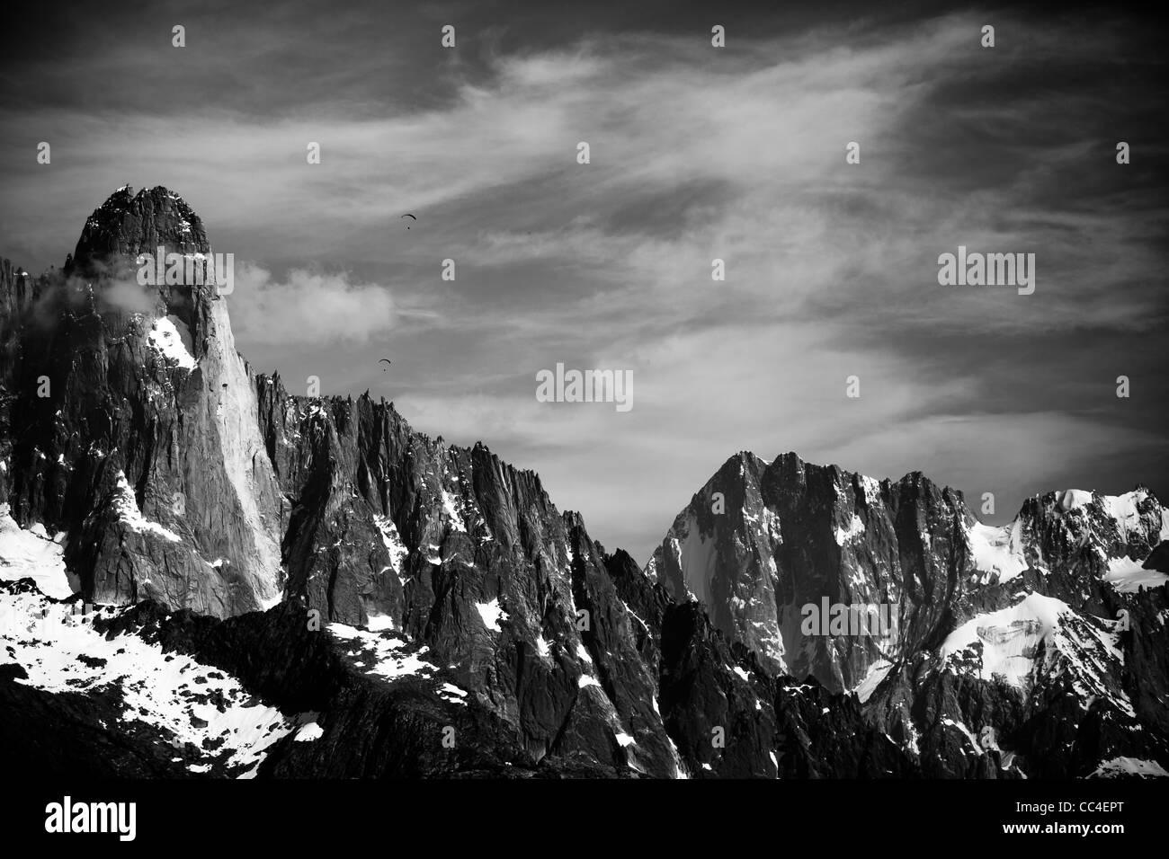 I parapendii battenti accanto a Les Drus in alto sopra le montagne di Chamonix, Francia. Gros Rognon in background. Foto Stock