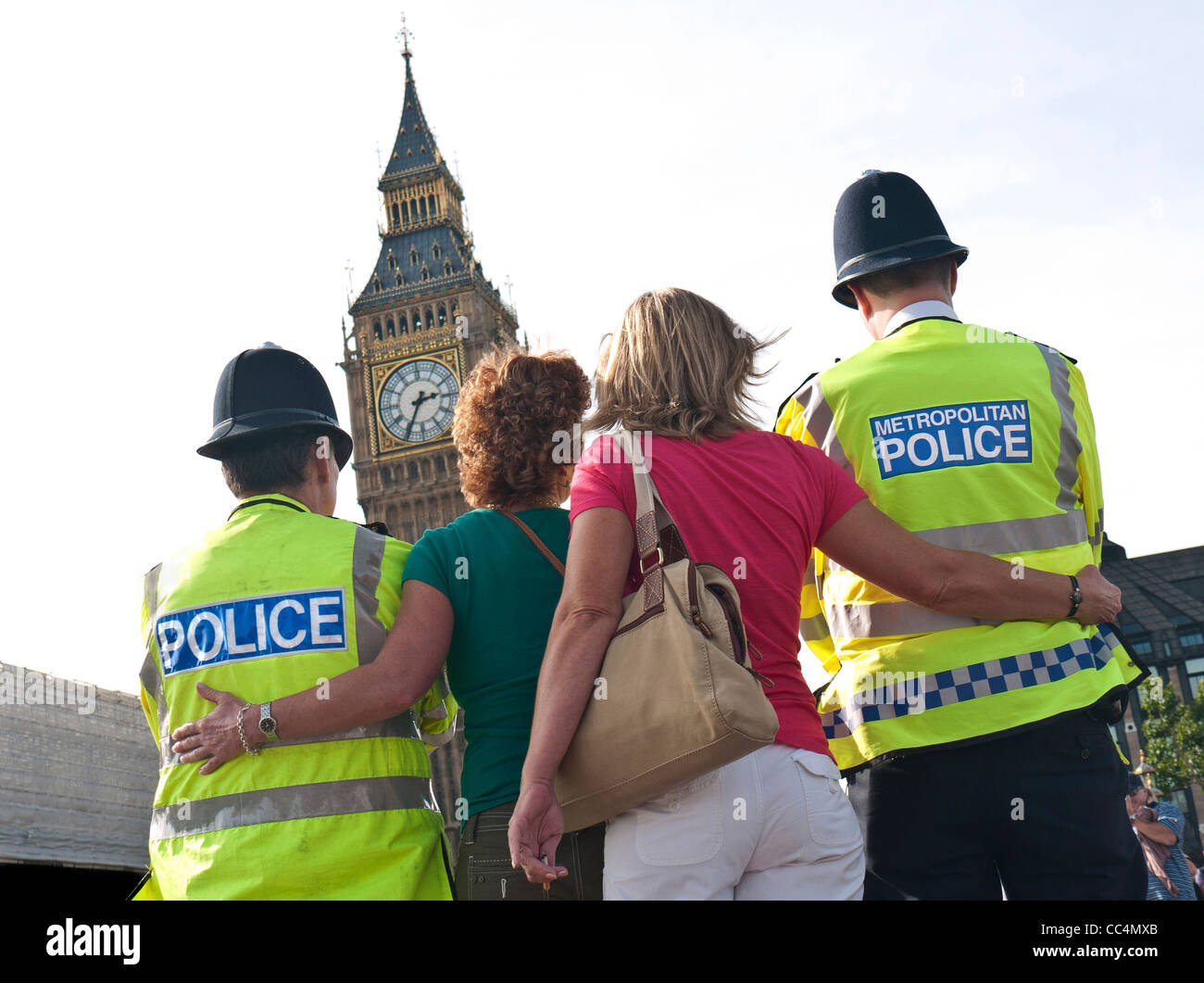 I turisti posano per una fotografia con cordiale London Metropolitan police officer presso Case del Parlamento Westminster London REGNO UNITO Foto Stock