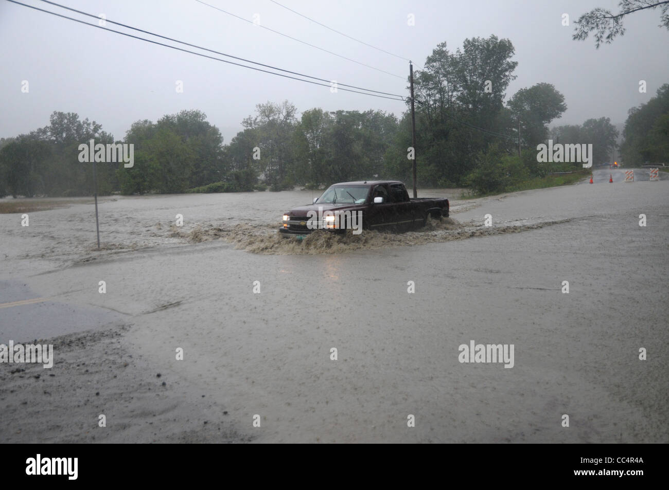 Un autista in un carrello tenta di guidare attraverso le acque di esondazione causata dalla tempesta tropicale Irene in Waitsfield, Vermont. Foto Stock Un autista in un carrello tenta di guidare attraverso le acque di esondazione causata dalla tempesta tropicale Irene in Waitsfield, Vermont. Foto Stock