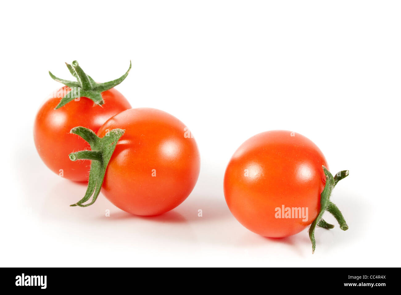 Organico casuale Pomodori ciliegia isolati su sfondo bianco Foto Stock