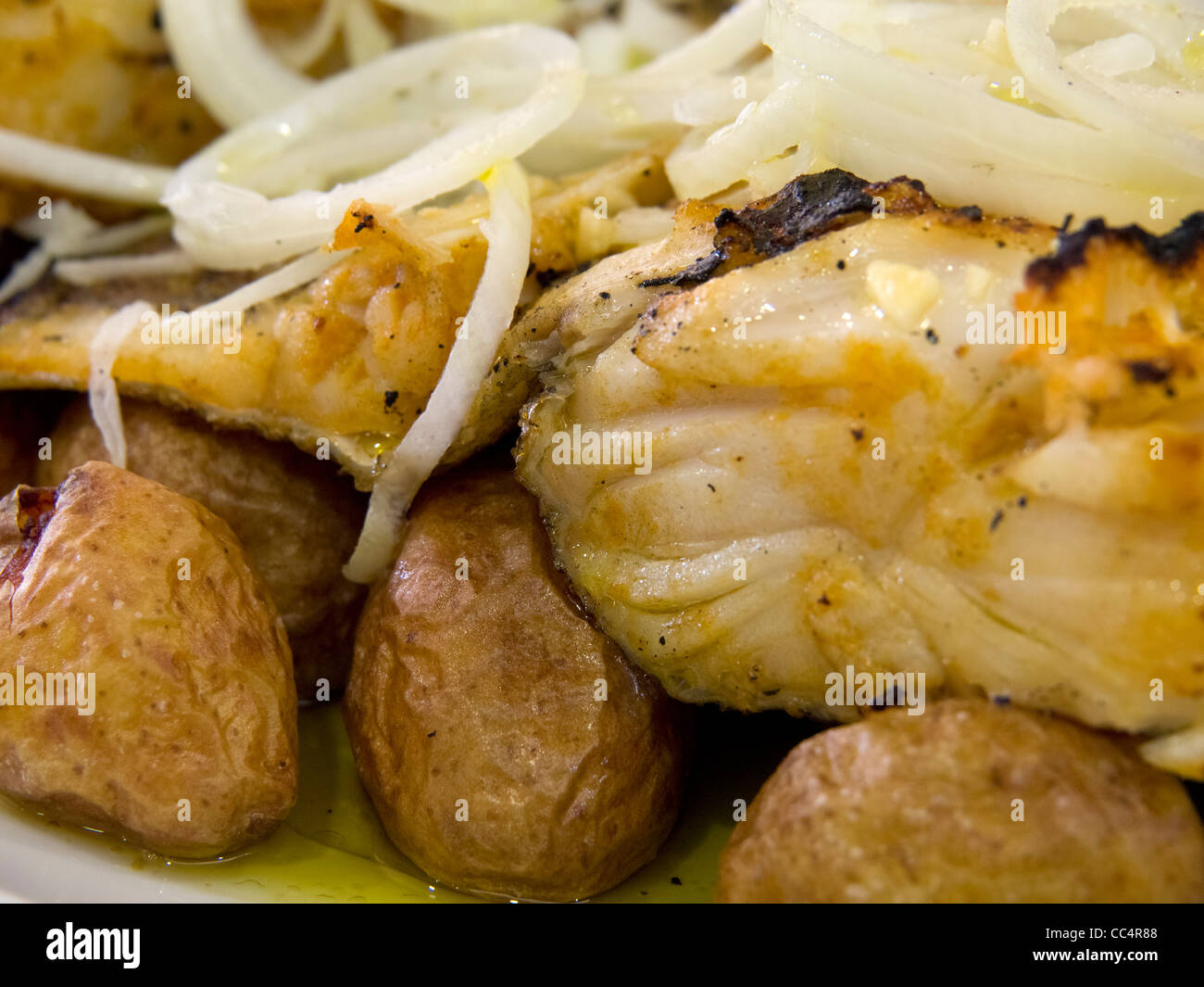 Piatto tipico portoghese Bacalhau a Lagareiro (baccalà con olio di oliva, cipolla e patate) Foto Stock