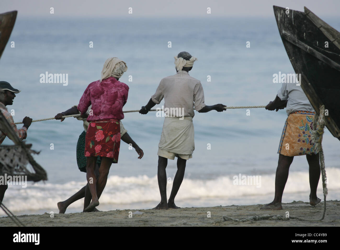 Fotografia di Roy Riley pescatori scacciando le loro reti sulla spiaggia a Kovalam in Kerala, India Foto Stock