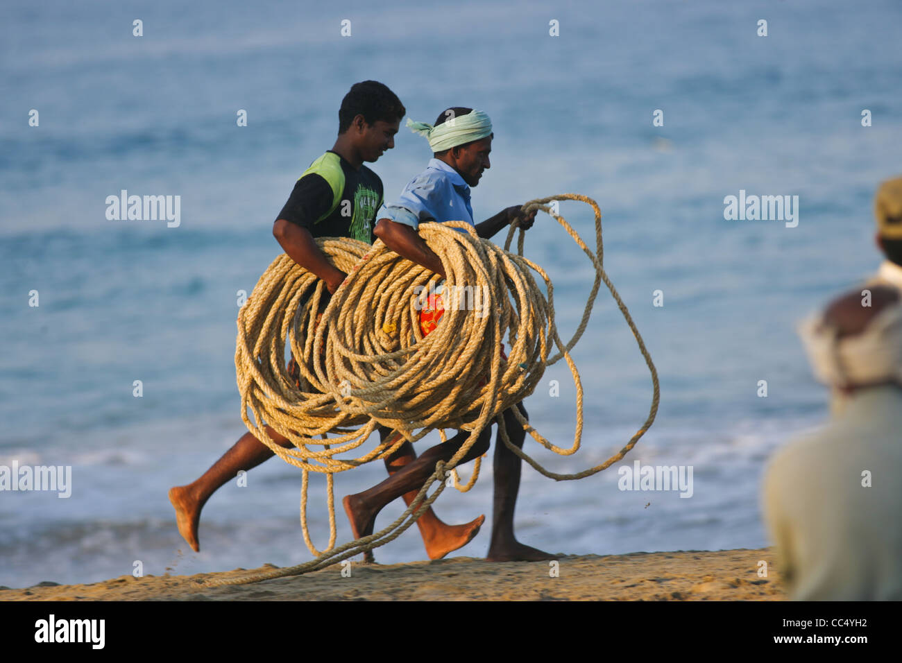 Fotografia di Roy Riley pescatori scacciando le loro reti sulla spiaggia a Kovalam in Kerala, India Foto Stock