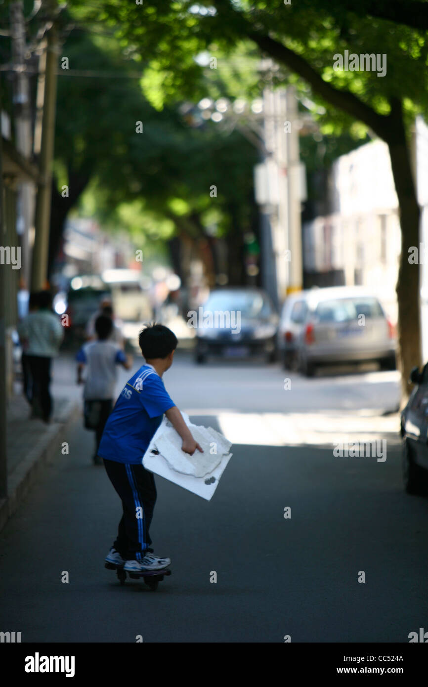 Ragazzo di equitazione, skateboard Fangjia Hutong a Pechino, Cina Foto Stock