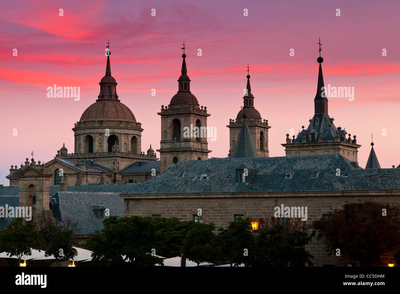 Il monastero di San Lorenzo de El Escorial con bellissimo cielo subito dopo il tramonto. Quattro torri sono impostate su off dal cielo con rosa e viola Foto Stock