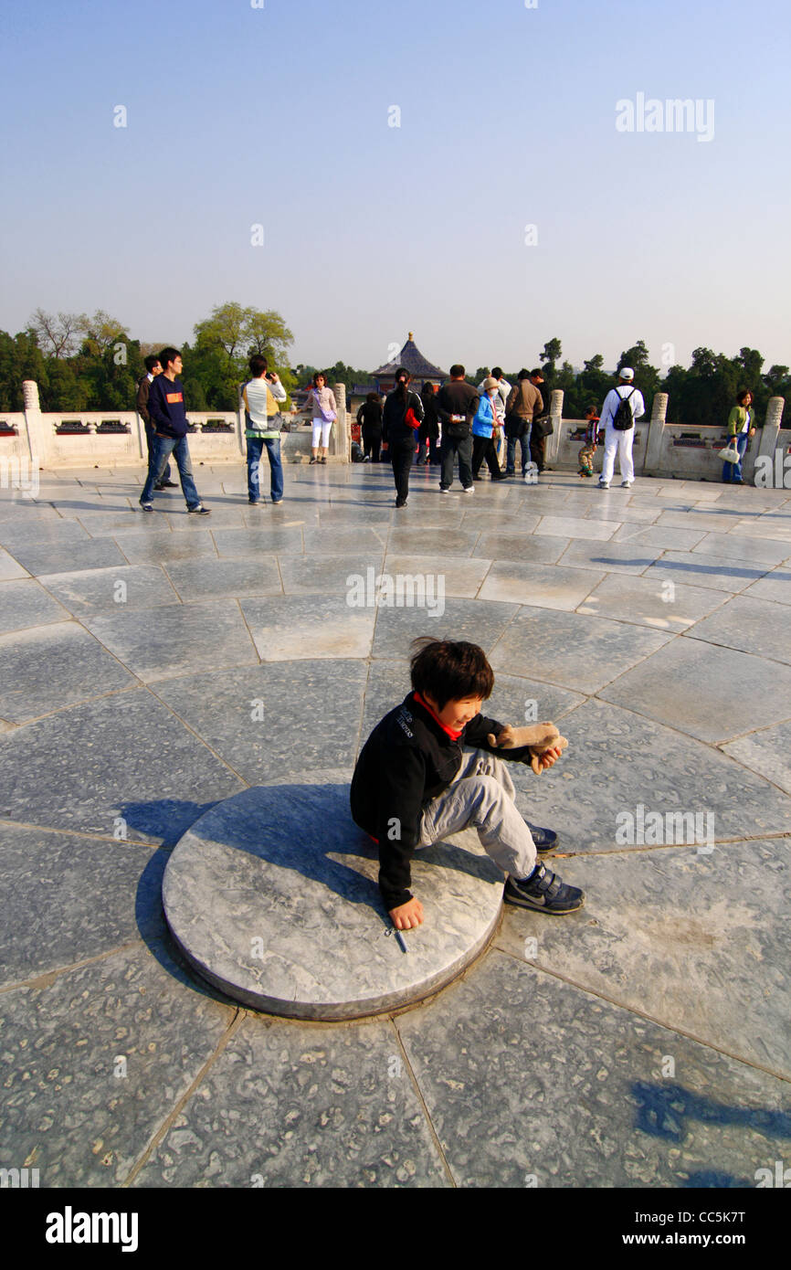 Ragazzo seduto su un cerchio di pietra di marmo, il Tempio del Cielo a Pechino, Cina Foto Stock