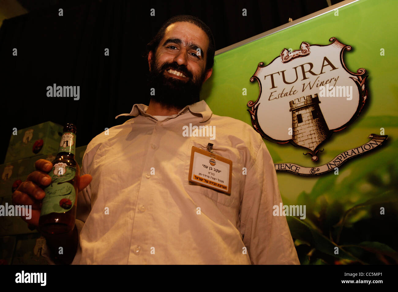 Un israeliano religiosa ebraica decantatore in posa con una bottiglia di locale birra israeliano Tura prodotta in Samaria area West Bank Israele Foto Stock