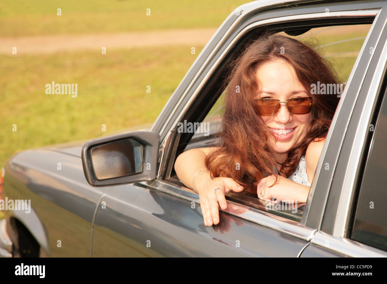 La donna sorride avendo trasformato nuovamente in una finestra di auto Foto Stock