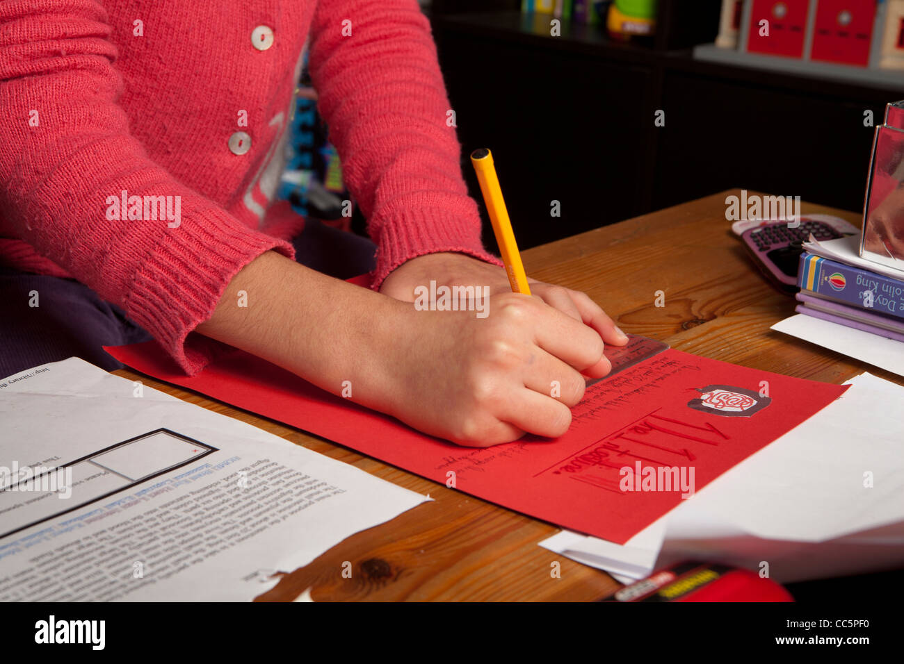 Close-up di una scolaretta iscritto i suoi compiti Foto Stock