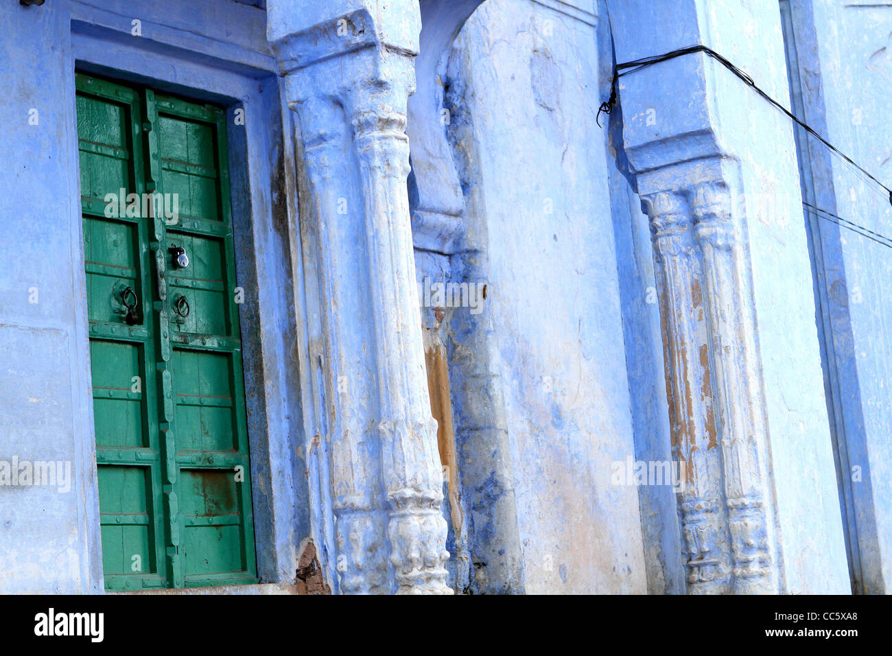 Verde tradizionale porta di legno e di pietra scolpita porta. Il Rajasthan. India Foto Stock