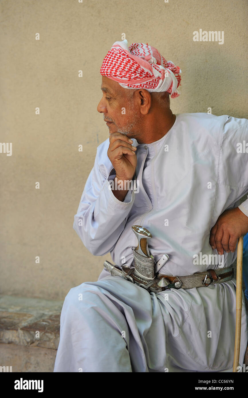 Un uomo Omani mostra con orgoglio è apprezzata khanjar, il tradizionale pugnale curvo, nel fucile e mercato khanjar in Nizwa, Oman. Foto Stock